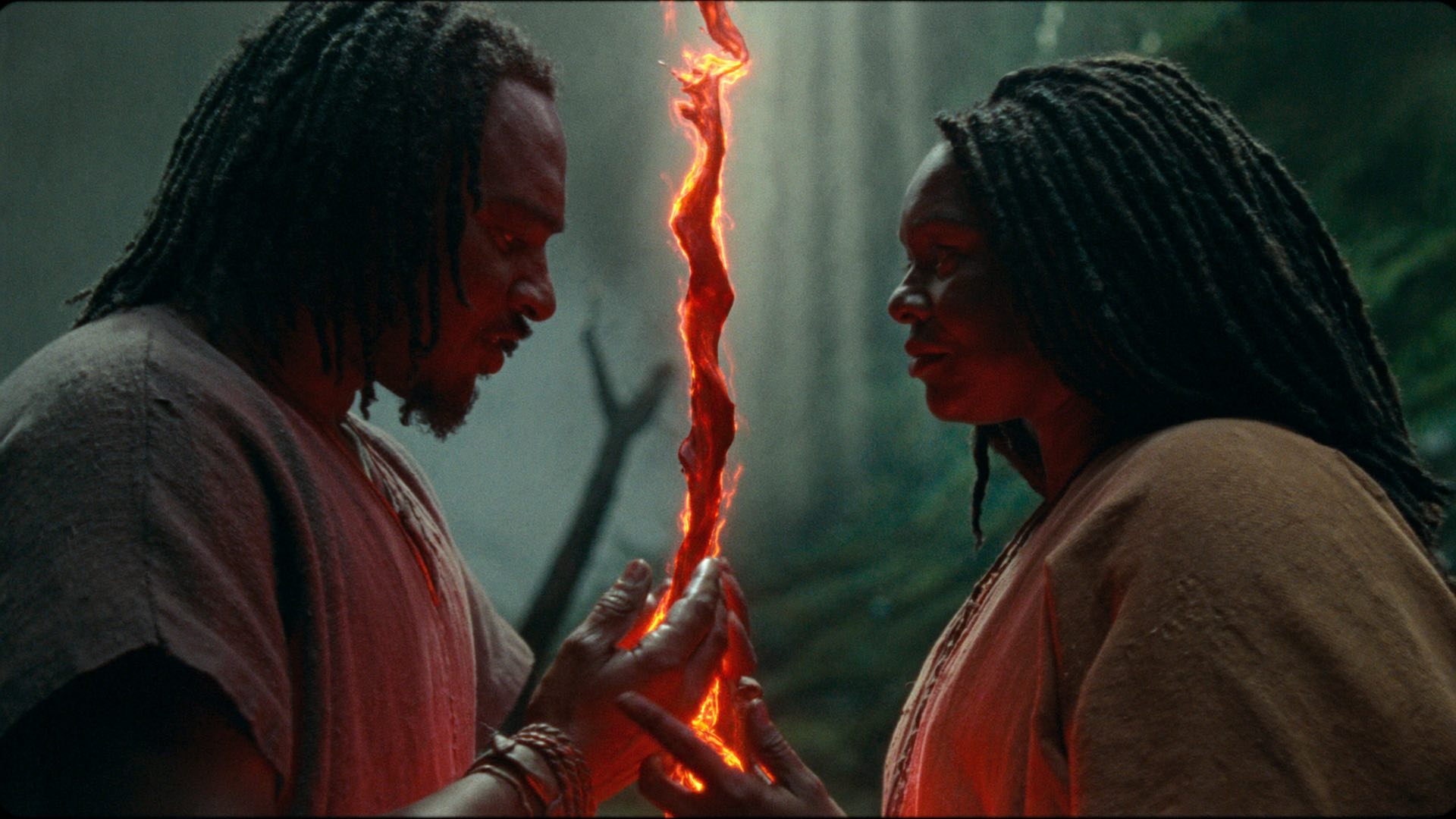 A man and a woman face each other in a misty forest, a glowing red thread of fire suspended between their open hands — the bloodline made visible.